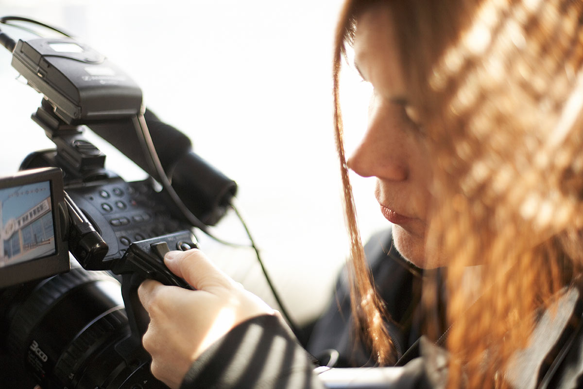 A woman works with a camera.