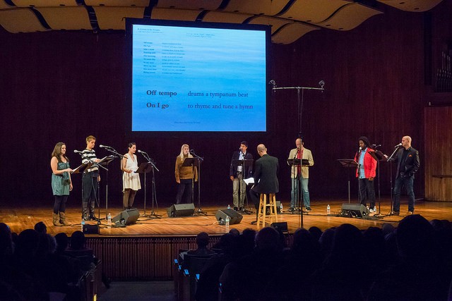 A group of singers perform onstage.