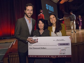 Three people pose with a large oversized check reading "Sound Spark $10,000"