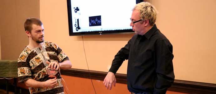 A student and a visiting artist talk in a music class.