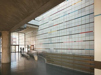 A large atrium with a wall of colorful geometric patterns.