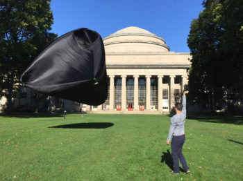 Photo of man interacting with floating sculptures from the Aerocene Project