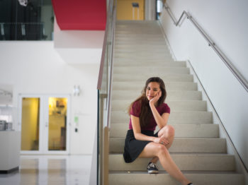 A student poses on a staircase.