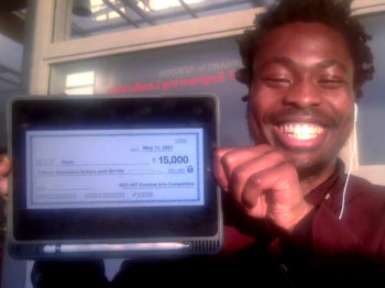 First prize recipient holds up iPad displaying an image of the $15,000 check.